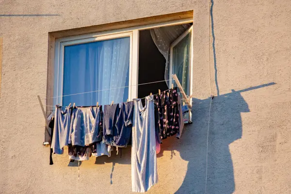 Çamaşırlar çok katlı bir binanın balkonunda kuruyor.