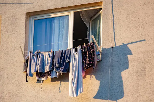 Çamaşırlar çok katlı bir binanın balkonunda kuruyor.
