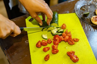 Salata için salatalık ve domates dilimliyorum.