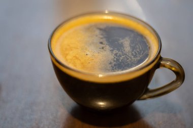 Masada şeffaf bir fincanda kahve.