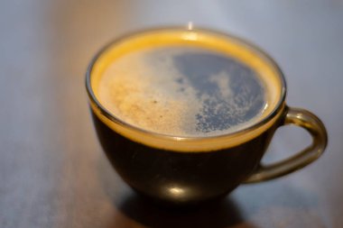 Masada şeffaf bir fincanda kahve.