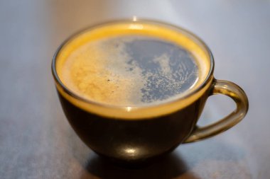 Masada şeffaf bir fincanda kahve.