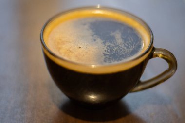 Masada şeffaf bir fincanda kahve.