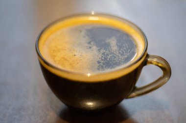 Masada şeffaf bir fincanda kahve.