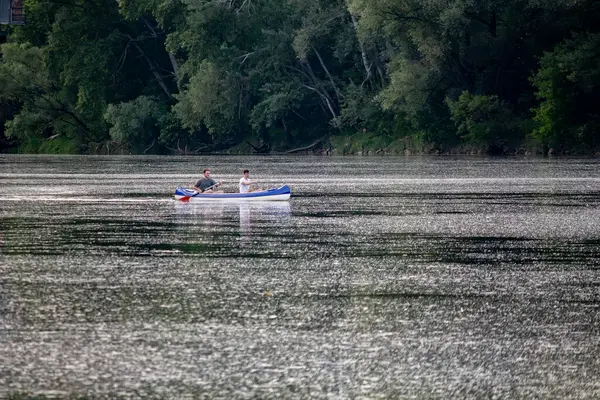 İnsanlar nehir boyunca bir teknede yelken açıyor.