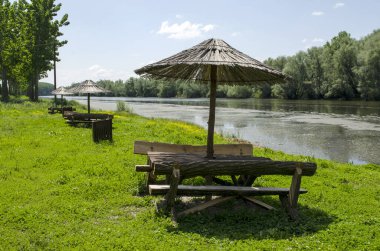 Şemsiye ve banklar Irmak Bosut, Srem, Voyvodina, Sırbistan.