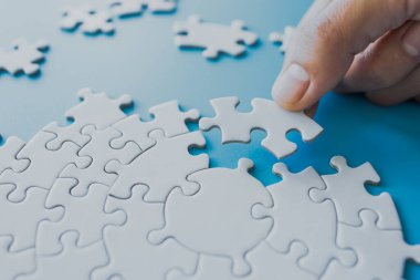  Beyaz yapboz parçaları mavi arkaplanda, yapbozun son parçası, uzayı kopyala..