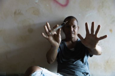 İnsan eli uzanmaya çalışıyor, beton zeminde. Uyuşturucu bağımlılığı ve yoksunluk belirtileri konsepti. Uyuşturucu Bağımlılığına Karşı Uluslararası Gün.