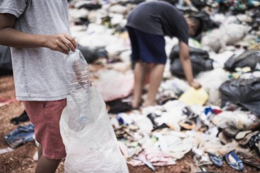  Fakir çocuklar çöp topluyor çöp yığınlarında yaşayan insanlar geri dönüşümlü atık toplamak için yürüyor yoksulluk konsepti dünya çevre gününe satılmak üzere..