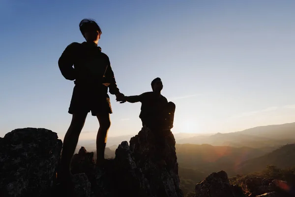 Silueta Excursionista Ayudándose Mutuamente Subir Una Montaña Atardecer Personas Ayudando —  Fotos de Stock