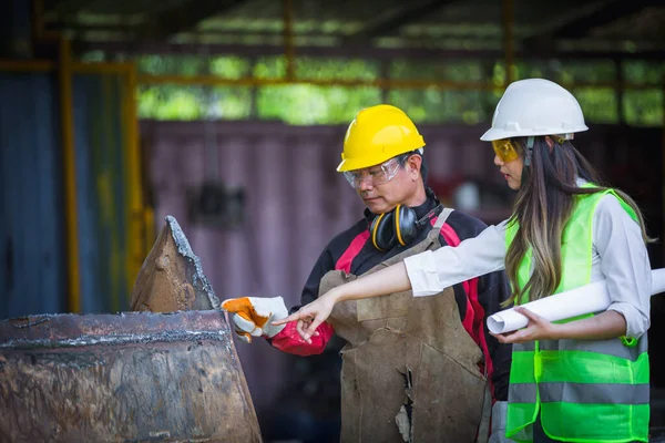 アジアの女性技術者が労働者の溶接をチェック — ストック写真