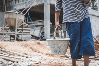 Children violence and abused concept. Little boy labor working in commercial building structure, World Day Against Child Labour concept.