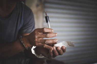 Uyuşturucu kaçakçıları eroinleriyle birlikte tutuklandı. Polis uyuşturucu kaçakçılarını kelepçelerle tutukladı. Hukuk ve polis kavramı, Dünya Uyuşturucuyla Mücadele Günü, 26 Haziran, Uyuşturucu Bağımlılığına Karşı Uluslararası Gün.