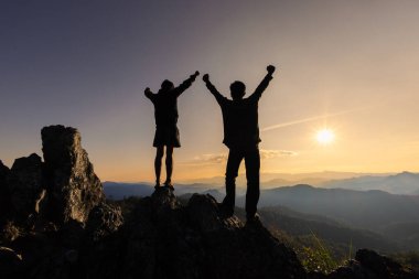 Dağdaki ekibin silueti. Liderlik kavramı, başarı.