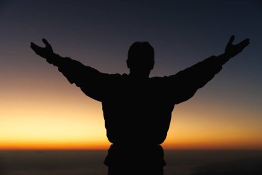 Erkeğin silueti, dua eden ruhaniyet ve din, tanrıya tapan kadın. Hristiyanlık dini kavramı. Dindar insanlar Tanrı 'ya karşı alçakgönüllüdür. Hıristiyanların Tanrı 'ya inancı ve umudu var..