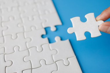 Yapboz ile güneş ışığı efektini birbirine bağlayan yakın el, iş çözümleri, başarı ve strateji kavramı