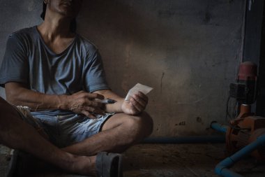 A heroin syringe in the hand of a drug addict. Drug concept. International drug abuse day.