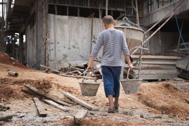  İnşaat alanında çalışan zavallı küçük çocuk, insan kaçakçılığı, fakir çocuk işçiliği. Çocuk işçi konseptine karşı dünya günü. 