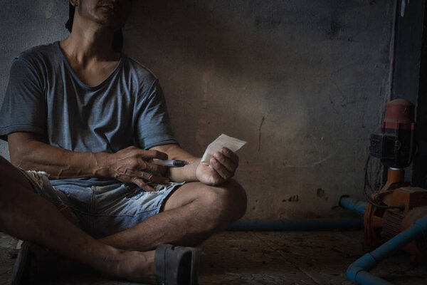 Шприц с героином в руке наркомана. Концепция наркотиков. Международный день наркомании.