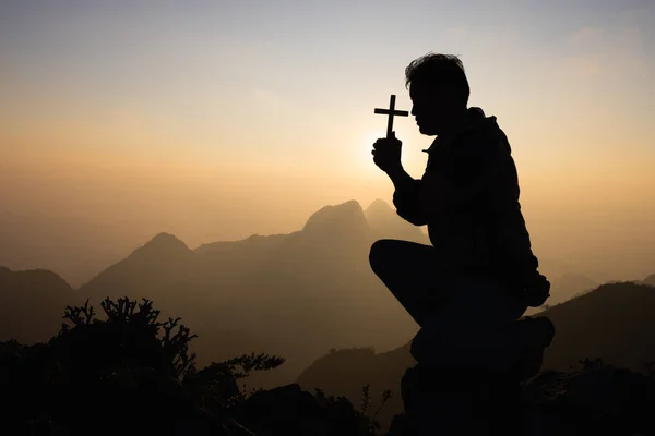 Silhouette off man praying for God\'s blessings with the power and power of the sacred On the background of sunrise. The concept of God and spirituality.