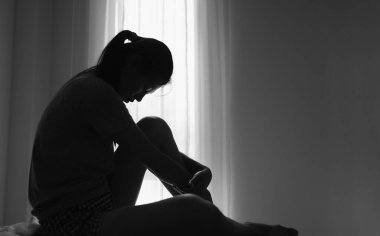 Depresyonda olan genç bir kadın, aile içi şiddet ve tecavüz, dövülmüş ve tecavüze uğramış, köşede oturmuş, boşluğu kopyalıyor. Uluslararası Kadınlar Günü