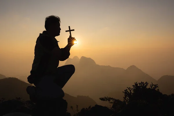 Silhouette of christian prayers raising hand while praying to the Jesus spirituality and religion,man praying to god. Christianity concept.  Pray for god blessing to wishing have a better life.