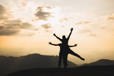 Gün batımının ortasında babasının boynunda gezen bir çocuğun silueti Mutlu bayram konsepti Mutlu aile.