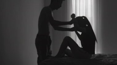 Savunmasız bir kadına saldıran bir adamın silüeti. Kadınlara Karşı Şiddeti Durdurma Kavramı, Aile İçi Şiddet, Şiddet mağduru Kadın.
