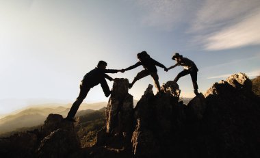 Silüet erkek ve kadın yürüyüşçüler dağ uçurumuna tırmanıyorlar. Yardım ve ekip çalışması konsepti. Bağımsız yürüyüş, başarı.
