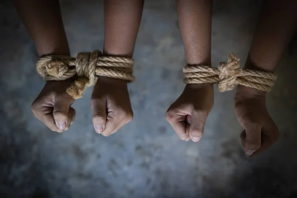 Child abuse concept, Child rights violations, violence against children and human trafficking. Human hands was tied with a rope, International human rights day concept.
