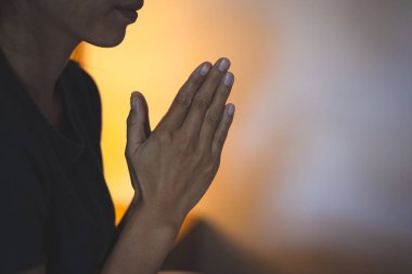 İnanç için dua kavramına sarılmış eller, sabah Tanrı 'ya dua eden dindar genç bir kadın, maneviyat ve din, dini kavramlar..