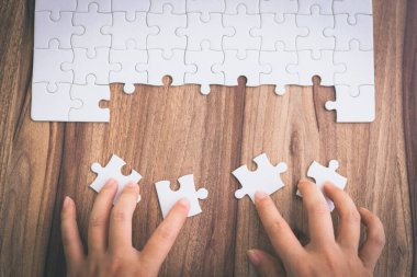 Görevi tamamlamak için yapbozun son parçasını el koydu. Yapboz parçaları birleştirme kavramı, problem çözme, takım çalışması ve başarı.