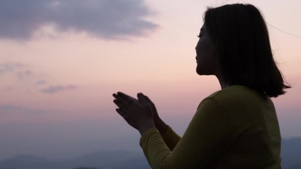 ゆっくりとした動き 美しい日の出の背景 美しい風景 スピリチュアリティ キリスト教の概念を祈る女性のシルエット — ストック動画