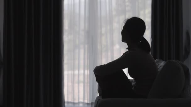 집에서 우울증으로 고통받는 사람의 실루엣 소파에 우울한 여자는 스트레스를 느낀다 — 비디오