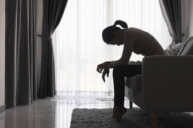 Depresyonda olan genç bir kadın; aile içi şiddet ve tecavüz; köşede oturan dövülmüş ve tecavüze uğramış; Kadınlara Yönelik Şiddeti Kaldırma Günü.