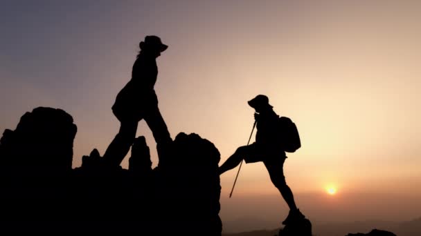 Siluet Dari Dua Wisatawan Membantu Tangan Mendaki Tebing Gunung Membantu — Stok Video