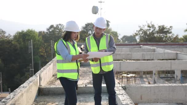男性および女性の土木技術者は 建設中のプロジェクトを検査および分析する エンジニアリングと建築コンセプト — ストック動画