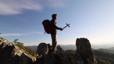 Gün batımında elinde Hristiyan haçı tutan bir adamın silueti. Allah 'ı anmak için yapılan dualar Özgürlükle dolu bir hayat.