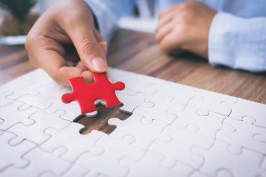 Yapboz 'u birbirine bağlayan kadının eli. İş çözümleri, başarı ve strateji kavramı. 