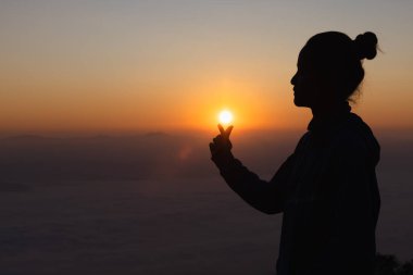 Aşk dolu kalp şeklinde eller, kalp şeklinde kadın elleri gökyüzüne karşı güneş ışınlarını uzat. Aşkta mutlu..
