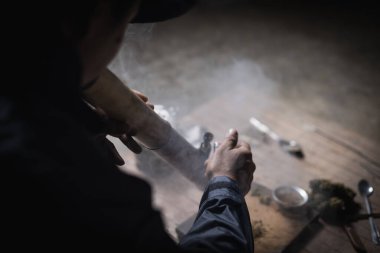 A man prepares marijuana on a cutting board to smoke, person who smokes drugs, drug addict, Drugs addiction and withdrawal symptoms concept. drugsInternational Day against Drug Abuse.