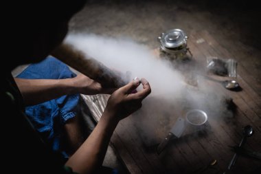 A man prepares marijuana on a cutting board to smoke, person who smokes drugs, drug addict, Drugs addiction and withdrawal symptoms concept. drugsInternational Day against Drug Abuse.