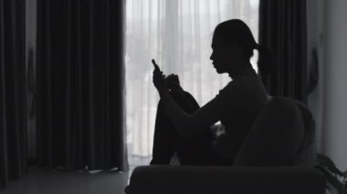 Stresli ve depresyondan muzdarip bir kadının silueti. Endişeli genç kadın umutsuzluk ve stres. Yalnız ve mutsuz kadınlar sosyal kurbanlardır. Evde yalnızlık gençliği.