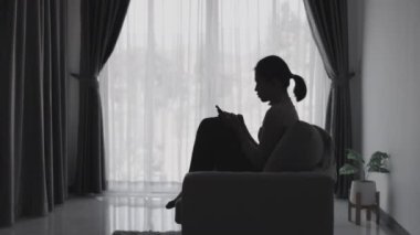 Stresli ve depresyondan muzdarip bir kadının silueti. Endişeli genç kadın umutsuzluk ve stres. Yalnız ve mutsuz kadınlar sosyal kurbanlardır. Evde yalnızlık gençliği.