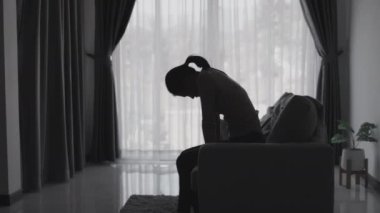 Stresli ve depresyondan muzdarip bir kadının silueti. Endişeli genç kadın umutsuzluk ve stres. Yalnız ve mutsuz kadınlar sosyal kurbanlardır. Evde yalnızlık gençliği.