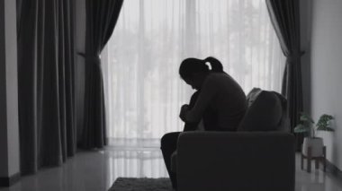 Stresli ve depresyondan muzdarip bir kadının silueti. Endişeli genç kadın umutsuzluk ve stres. Yalnız ve mutsuz kadınlar sosyal kurbanlardır. Evde yalnızlık gençliği.