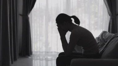 Stresli ve depresyondan muzdarip bir kadının silueti. Endişeli genç kadın umutsuzluk ve stres. Yalnız ve mutsuz kadınlar sosyal kurbanlardır. Evde yalnızlık gençliği.