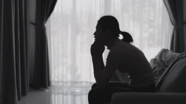 Stresli ve depresyondan muzdarip bir kadının silueti. Endişeli genç kadın umutsuzluk ve stres. Yalnız ve mutsuz kadınlar sosyal kurbanlardır. Evde yalnızlık gençliği.
