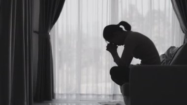 Stresli ve depresyondan muzdarip bir kadının silueti. Endişeli genç kadın umutsuzluk ve stres. Yalnız ve mutsuz kadınlar sosyal kurbanlardır. Evde yalnızlık gençliği.