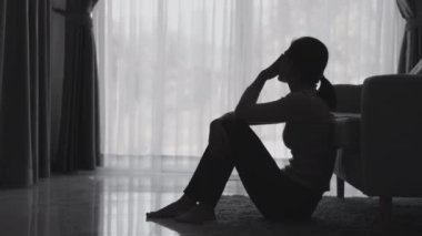 Stresli ve depresyondan muzdarip bir kadının silueti. Endişeli genç kadın umutsuzluk ve stres. Yalnız ve mutsuz kadınlar sosyal kurbanlardır. Evde yalnızlık gençliği.